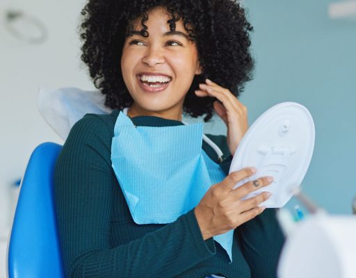 Shot of a young woman admiring her teeth after having a dental procedure done